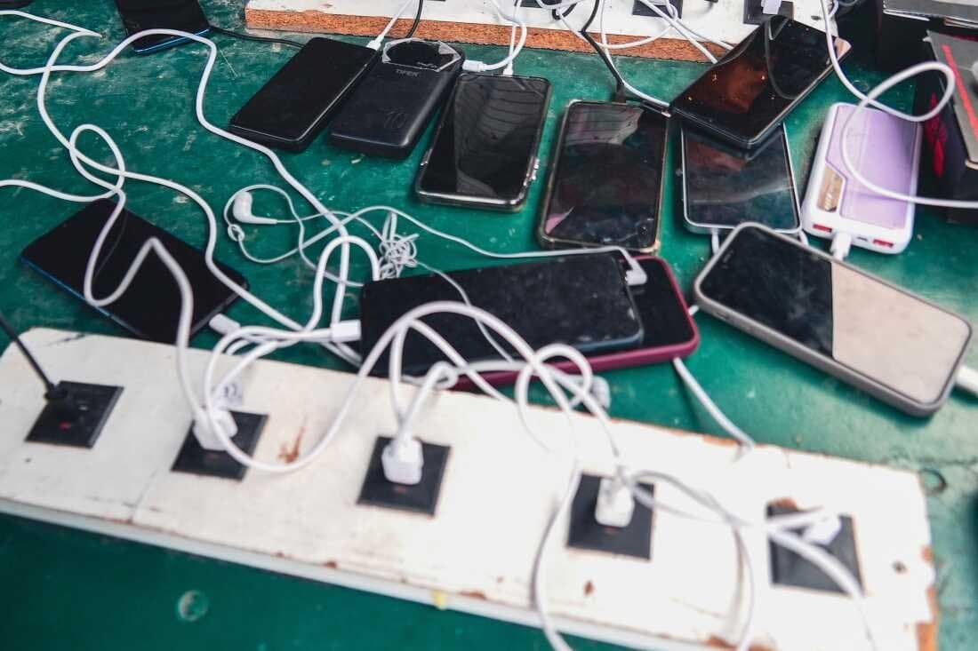 FILE - Phones are kept for charging at a Doctors Without Borders informal camp in Mardyck, northern France, Wednesday, July 2, 2025.